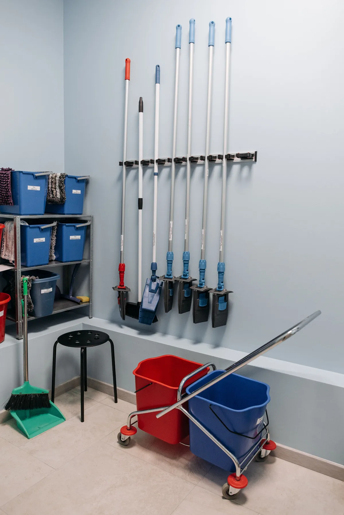Organised cleaning tools and buckets in a tidy utility area